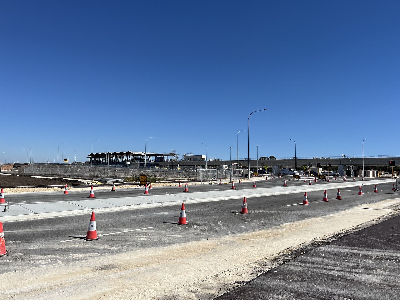 A construction site beside a road marked with traffic cones.